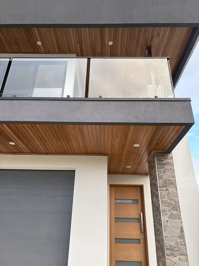 Timber-lined balcony soffit and stone entrance detail